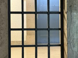 Fenster mit Metallstäben in einer Steinmauer.