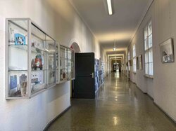 Korridor mit Schließfächern, Kunstwerken und Vitrinen.